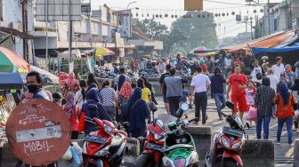 Warga berlalu - lalang di sekitaran rel kereta api Pasar Anyar, Bogor, Jawa Barat, Jumat (22/5). [Suara.com/Alfian Winanto]
