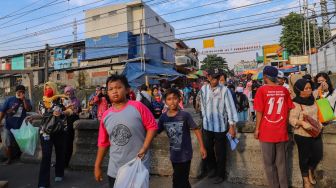 Warga berlalu - lalang di sekitaran rel kereta api Pasar Anyar, Bogor, Jawa Barat, Jumat (22/5). [Suara.com/Alfian Winanto]
