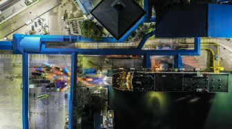 Foto aerial kendaraan logistik tujuan Sumatera antre memasuki kapal di Pelabuhan Merak Banten, Kamis (21/5) malam. [ANTARA FOTO/Galih Pradipta]
