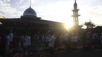 Umat Islam melaksanakan shalat Idul Fitri 1 Syawal 1441 Hijriah secara berjamaah di ruas Jalan Jenderal Sudirman, Kranji, Bekasi, Jawa Barat, Minggu (24/5). [Suara.com/Angga Budhiyanto]