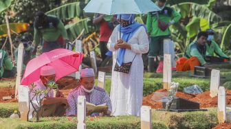 Keluarga berdoa di makam khusus korban Covid-19 di TPU  Pondok Ranggon, Jakarta Timur, Senin (25/5). [Suara.com/Alfian Winanto]