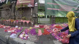 Warga melakukan ziarah kubur saat Hari Raya Idul Fitri di luar pagar kawasan Pemakaman Muslim Wanasari, Denpasar, Bali, Minggu (24/5).  [ANTARA FOTO/Fikri Yusuf]