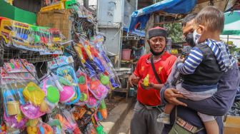 Orang Tua Ajak Anaknya Berburu Mainan di Pasar Gembrong saat Covid-19