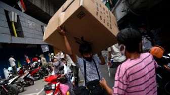 Warga memanggul barang dagangannya saat berlangsung penertiban di kolong jembatan layang Pasar Pagi Asemka, Jakarta Barat, Rabu (27/5). [ANTARA FOTO/Sigid Kurniawan]