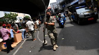 Anggota Satpol PP membawa barang milik pedagang saat penertiban di kolong jembatan layang Pasar Pagi Asemka, Jakarta Barat, Rabu (27/5). [ANTARA FOTO/Sigid Kurniawan]