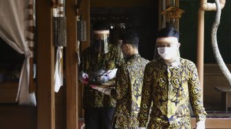 Pelayan menggunakan alat pelindung wajah, masker dan sarung tangan saat melayani pelanggan di salah satu rumah makan di kawasan Pajajaran, Kota Bogor, Jawa Barat, Jumat (29/5). [Suara.com/Angga Budhiyanto]