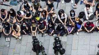 Polisi anti huru-hara menahan sekelompok orang selama demonstrasi di kawasan Causeway Bay, Hong Kong, Rabu (27/5). [Isaac Lawrence / AFP]