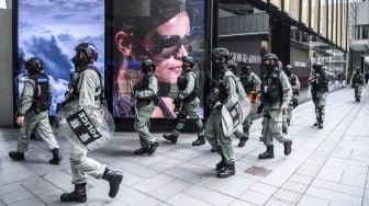 Polisi anti huru-hara mengambil bagian dalam operasi pembubaran kerumunan di pusat kota Hong Kong, Rabu (27/5). [Anthony Wallace / AFP]