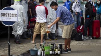 Seorang Warga Negara Indonesia (WNI) yang menjadi Anak Buah Kapal (ABK) Kapal Pesiar MV Nieuw Amsterdam membuang minuman beralkohol seusai menjalani pemeriksaan oleh petugas bea cukai di Pelabuhan JICT 2, Tanjung Priok, Jakarta, Jumat (29/5). [ANTARA FOTO/Dhemas Reviyanto]