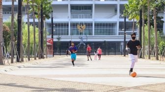 Anak - anak bermain bola di Kompleks Olahraga Gelora Bung Karno, Jakarta Pusat, Minggu (31/5). [Suara.com/Alfian Winanto]