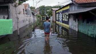 Warga berjalan melewati banjir rob di Slamaran, Pekalongan, Jawa Tengah, Senin (1/6/2020). [ANTARA FOTO]
