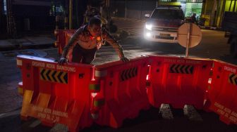 Petugas Kepolisian menyingkirkan pembatas untuk membuka ruas jalan Kawasan Naripan, Bandung, Jawa Barat, Senin (1/6). [ANTARA FOTO/Novrian Arbi]