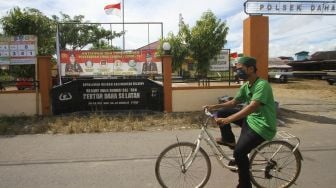 Warga menggunakan sepeda melintas di depan Polsek Daha Selatan pasca penyerangan di Kabupaten Hulu Sungai Selatan, Kalimantan Selatan, Selasa (2/6/2020). [ANTARA FOTO/Bayu Pratama ]