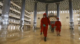 Petugas pemadam kebakaran melakukan penyemprotan cairan disinfektan di Masjid Istiqlal, Jakarta, Rabu (3/6). [Suara.com/Angga Budhiyanto]