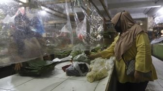 Pembeli berbelanja di lapak yang dipasangi tirai plastik di Pasar Bandeng, Kota Tangerang, Banten, Selasa (2/6). [Suara.com/Angga Budhiyanto]
