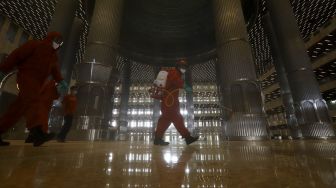 Petugas pemadam kebakaran melakukan penyemprotan cairan disinfektan di Masjid Istiqlal, Jakarta, Rabu (3/6). [Suara.com/Angga Budhiyanto]