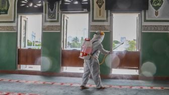 Petugas menyemprotkan disinfektan jendela - jendela di dalam Masjid Agung Al-Azhar, Jakarta Selatan, Rabu (3/6). [Suara.com/Alfian Winanto]