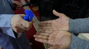 Petugas Masjid menyemprotkan Hand Sanitizer ke warga Gaza yang melakukan salat subuh berjamaah di Masjid Al-Buhari di Deir Al-Balah, Gaza pada 3 Juni 2020. [Foto/Anadolu Agency]

