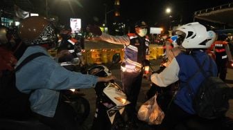 Petugas meminta pengendara kendaraan bermotor untuk berputar balik di Jalan Rungkut Menanggal, Surabaya, Jawa Timur, Kamis (4/6). [ANTARA FOTO/Didik Suhartono]