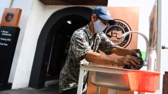 Seorang pekerja membersihkan keran air cuci tangan di Museum Bahari, Jakarta, Sabtu (6/6/2020). [ANTARA FOTO/M Risyal Hidayat]

