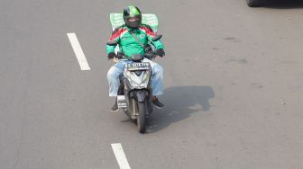 Pengemudi ojek online membawa barang di daerah Kalibata, Jakarta Selatan, Sabtu (6/6). [Suara.com/Alfian Winanto]