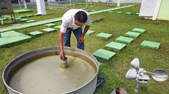 Petugas BMKG (Badan Meteorologi Klimatologi dan Geofisika) memeriksa alat ukur penguapan (Open Pan Evaporimeter) di Laboratorium Terbuka BMKG Serang, Banten, Sabtu (6/6/2020). [ANTARA FOTO/Asep Fathulrahman]