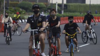 Sejumlah warga berolahraga menggunakan sepeda di kawasan Bundaran HI, Jakarta, Minggu (7/6). [Suara.com/Angga Budhiyanto]