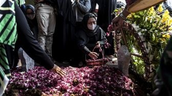 Istri almarhum Lettu Wisnu Tia Aruni, Yuanita Rahmawati menabur bunga pada pusara suaminya usai prosesi pemakaman di Tempat Pemakaman Umum Kembangarum (Bergota II), Semarang, Jawa Tengah, Minggu (7/6). [ANTARA FOTO/Aji Styawan]