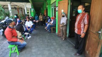 Sejumlah orang tua/wali murid mengantre saat pengambilan surat keterangan lulus pelajar kelas IX di SMP Taman Dewasa Jetis, Yogyakarta, Senin (8/6/2020). [ANTARA FOTO/Andreas Fitri Atmoko]

