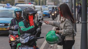 Driver ojek online memberikan handsinitizer kepada penumpang di Jalan Sudirman, Jakarta Pusat, Senin (8/6). [Suara.com/Alfian Winanto]
