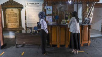 Pengunjung menerapkan physical distancing saat membeli tiket masuk di Museum Bahari, Jakarta Utara, Selasa (9/6). [Suara.com/Alfian Winanto]