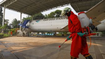 Petugas menyemprotkan disinfektan di museum Transportasi, Taman Mini Indonesia Indah, Jakarta Timur, Rabu (10/6). [Suara.com/Alfian Winanto]