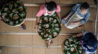 Pedagang dengan membawa nasi tumpeng memanjatkan doa saat Syukuran Pedagang di Pasar Kadipolo, Solo, Jawa Tengah, Rabu (10/6/2020). . [ANTARA FOTO/Mohammad Ayudha]