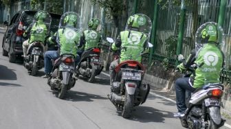 Pengemudi ojek online mengenakan sekat pelindung saat melintas di kawasan jalan Kendal, Jakarta, Rabu (10/6/2020).   [ANTARA FOTO/Galih Pradipta]