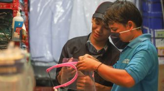 Pedagang merakit face shield untuk dijual di Pasar Pramuka, Jakarta Timur, kamis (11/6). [Suara.com/Alfian Winanto]
