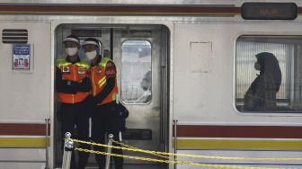 Petugas keamanan berjaga di gerbong Kereta Rel Listrik (KRL) di Stasiun Tanah Abang, Jakarta, Jumat (12/6). [Suara.com/Angga Budhiyanto]