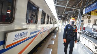 Petugas berjalan di dekat rangkaian Kereta Api (KA) Serayu di Stasiun Pasar Senen, Jakarta, Jumat (12/6). [ANTARA FOTO/Nova Wahyudi]