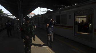 Seorang calon penumpang berjalan memasuki gerbong Kereta Rel Listrik (KRL) di Stasiun Tanah Abang, Jakarta, Jumat (12/6). [Suara.com/Angga Budhiyanto]