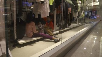 Dua anak berada di salah satu gerai pakaian di Mall Kota Kasablanka, Jakarta, Selasa (16/6). [Suara.com/Angga Budhiyanto]