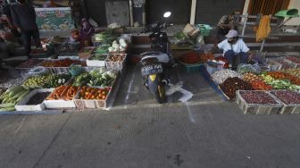 Pedagang menata dagangannya di Pasar Perumnas Klender, Jakarta, Selasa (16/6). [Suara.com/Angga Budhiyanto]