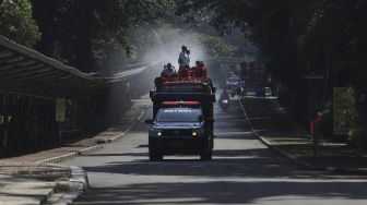 Petugas Pemadam Kebakaran (Damkar) menyemprotkan cairan disinfektan di lingkungan Taman Margasatwa Ragunan (TMR), Jakarta, Rabu (17/6). [Suara.com/Angga Budhiyanto]