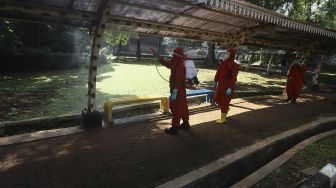 Petugas Pemadam Kebakaran (Damkar) menyemprotkan cairan disinfektan di lingkungan Taman Margasatwa Ragunan (TMR), Jakarta, Rabu (17/6). [Suara.com/Angga Budhiyanto]
