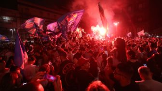 Suporter Napoli merayakan kemenangan atas Juventus pada final Coppa Italia di pusat Kota Napoli, Italia,Kamis (18/6) dini hari WIB.  [Carlo Herman/AFP]