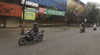 Sejumlah kendaraan melintas di Pasar Kebayoran Lama yang ditutup di Jakarta, Kamis (18/6). [Suara.com/Angga Budhiyanto]