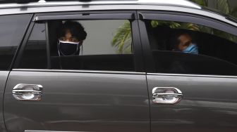 Seorang murid berada di dalam mobil menunggu giliran untuk menerima pengalungan medali dari guru sebagai tanda wisuda kelulusan sekolah secara "Drive Thru" di Madrasah Aliyah Annajah, Ciledug Raya, Jakarta, Jumat (19/6). [Suara.com/Angga Budhiyanto]