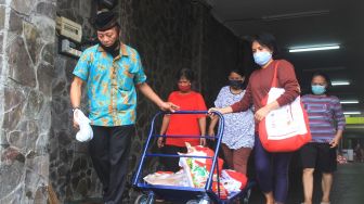 Warga usai mengambil paket sembako di Gedung GP Ansor, Kramat Raya, Jakarta Pusat, Jumat (19/6/2020). [Suara.com/Oke Atmaja]