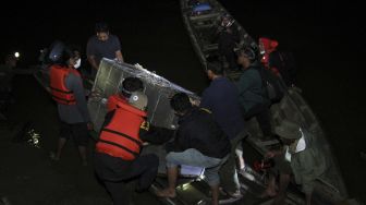 Petugas memindahkan kerangkeng berisi Harimau Sumatra liar dari mobil ke atas perahu sebelum proses pelepasliaran di Desa Gelombang, Kecamatan Sultan Daulat, Subulussalam, Aceh, Sabtu (20/6). [ANTARA FOTO/Syifa Yulinnas]