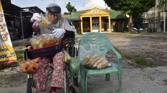 Seorang penyandang disabilitas, Yanti (34) mengenakan alat pelindung diri saat menjual makanan di jalanan Kota Pekanbaru, Riau, Sabtu (20/6). [ANTARA FOTO/FB Anggoro]