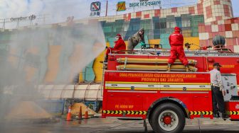 Petugas melakukan penyemprotan disinfektan di area Terminal Blok M, Jakarta Selatan, Selasa (23/6).  [Suara.com/Alfian Winanto]