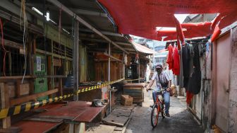 Warga melintas di sekitar area Pasar Cideng Thomas, Jakarta Pusat, Selasa (23/6). [Suara.com/Alfian Winanto]